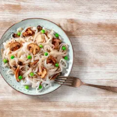 Talerz z makaronem konjac, pieczarkami i groszkiem. Inspiracja na zdrowe przepisy z makaronem konjac.
