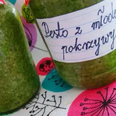 Dwa słoiki z zielonym pesto z młodej pokrzywy, gotowe do przechowywania.