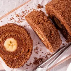 Czekoladowa, najprostsza rolada biszkoptowa z bananem w środku, posypana wiórkami. Idealna na deser.
