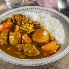 Pyszne danie z ryżem i kurczakiem w aromatycznym sosie przyprawy curry, z kawałkami marchewki.