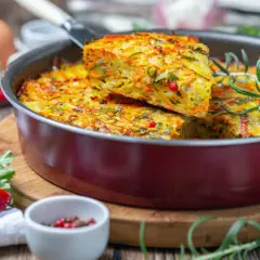 Pyszna, warzywna zapiekanka z jajek i warzyw, idealna na lekka kolacja. Podana z gałązką rozmarynu i papryczką chili.