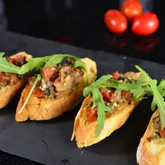 Cztery chrupiące bruschetty z pomidorami, ziołami i rukolą. Idealne tapas, co to jest? Pyszna przekąska!