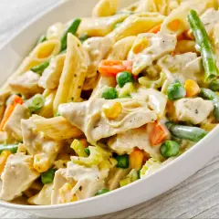 Penne z kurczakiem i kremowym sosem, wzbogacone o zieloną fasolkę, groszek i marchewkę. Pyszny makaron z warzywami.