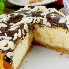 Pyszny sernik z airfryer, polany czekoladą i posypany płatkami migdałów. Idealny deser na każdą okazję.