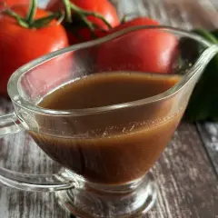 Sos balsamiczny w sosjerce, na tle pomidorów i zielonej papryki. Idealny do sałatek i mięs.
