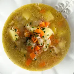 Gęsta, rozgrzewająca pejzanka z ziemniakami, marchewką i ziołami, podana w ozdobnej misce.