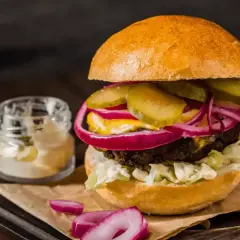 Pyszny hamburger z soczystą wołowiną, chrupiącą sałatą, piklami, czerwoną cebulą i majonezem. Idealny przepis na to, jak zrobić hamburgera.