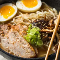 Pyszne ramen z plastrami wieprzowiny, jajkiem na pół i grzybami. Idealne, by dowiedzieć się, jak zrobić ramen.
