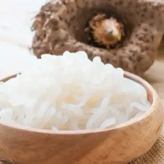 Miseczka pełna białego makaronu z mąki konjac, obok surowa bulwa.