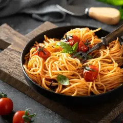 Pyszne spaghetti z pomidorkami i bazylią, idealne na smaczne obiady domowe przepisy. Widok z góry na talerz pełen makaronu.