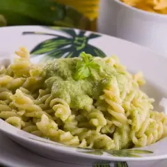 Pyszny makaron fusilli z kremowym sosem z cukinii, udekorowany listkiem bazylii. Idealny na szybki obiad.