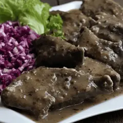 Pyszna wątróbka w sosie, podana z surówką z czerwonej kapusty i sałatą.