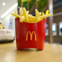 Złociste frytki McDonald's w czerwonym opakowaniu, idealne na szybką przekąskę. Zastanawiasz się nad frytki mcdonald kcal?