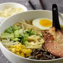 Miseczka aromatycznej zupy ramen z plastrem boczku, jajkiem i warzywami. To przepis oryginalny, który zachwyci każdego smakosza.