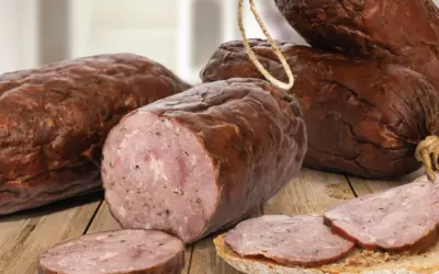 Kiełbasa żywiecka, wędzona, z widocznym przekrojem i plastrami na chlebie.