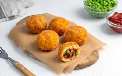 Arancini co to? Złociste kulki ryżowe z mięsem i groszkiem, chrupiące na zewnątrz, pyszne w środku.