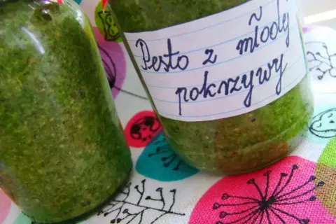 Dwa słoiki z zielonym pesto z młodej pokrzywy, gotowe do przechowywania.