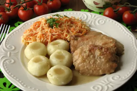 Bitki wieprzowe w sosie własnym z cebulką, podane z kluskami śląskimi i surówką z marchewki. Pyszny, domowy obiad.