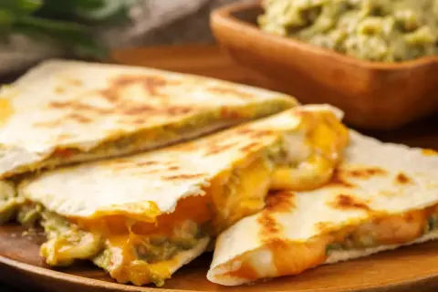Pyszna, prosta kolacja na ciepło: quesadillas z ciągnącym się serem i guacamole. Idealne na szybki posiłek.