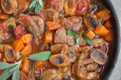 Pyszne ossobuco wołowe w sosie pomidorowym z marchewką i ziołami.