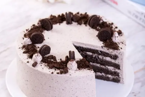Pyszny tort z masą oreo, udekorowany pokruszonymi ciastkami i całymi ciasteczkami. Idealny na każdą okazję.