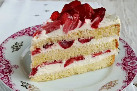 Pyszny biszkopt z serkiem mascarpone i bitą śmietaną, przełożony truskawkami. Idealny deser na każdą okazję.