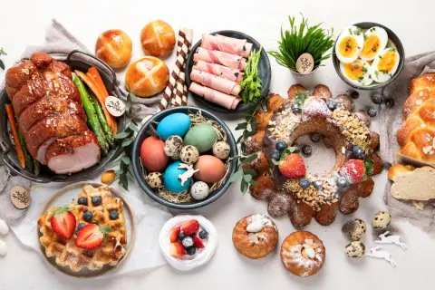 Wielkanocne przekąski: pieczony schab, babka, mazurek, jajka, pascha i słodkie bułeczki.