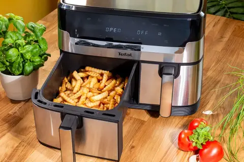 Frytki z frytkownicy beztłuszczowej Tefal, idealne do rankingu air fryer. Obok bazylia i pomidory.