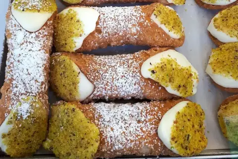Pyszne, chrupiące rurki z kremem i pistacjami. Idealny dobry przepis na ciasto na rurki, posypane cukrem pudrem.