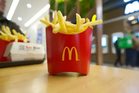 Złociste frytki McDonald's w czerwonym opakowaniu, idealne na szybką przekąskę. Zastanawiasz się nad frytki mcdonald kcal?