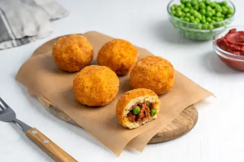 Arancini co to? Złociste kulki ryżowe z mięsem i groszkiem, chrupiące na zewnątrz, pyszne w środku.