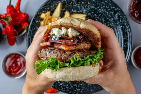 Prawdziwe burgery przepis: soczysta wołowina, chrupiący bekon, ser pleśniowy i świeża sałata w domowej bułce. Idealne na obiad!