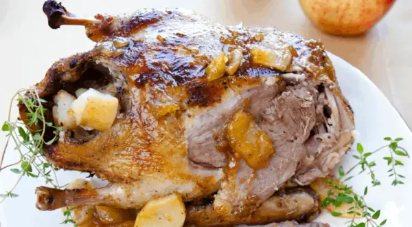 Pieczona kaczka nadziewana mięsem mielonym i wątróbką, podana z jabłkami i ziołami. Przepis na wyśmienite danie.