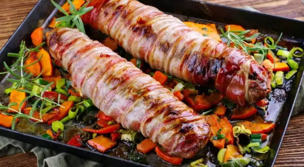 Pieczone polędwiczki wieprzowe w boczku, podane z pieczonymi warzywami i rozmarynem. Pyszna okrasa na obiad.