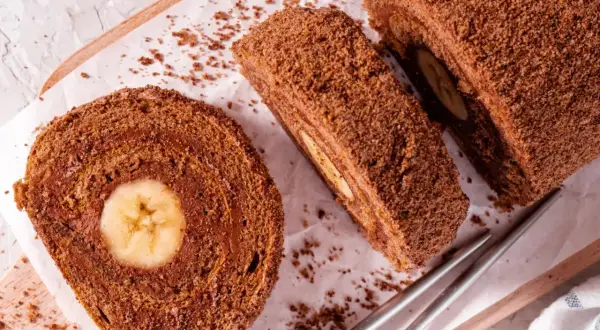 Czekoladowa, najprostsza rolada biszkoptowa z bananem w środku, posypana wiórkami. Idealna na deser.