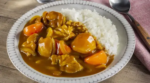 Pyszne danie z ryżem i kurczakiem w aromatycznym sosie przyprawy curry, z kawałkami marchewki.