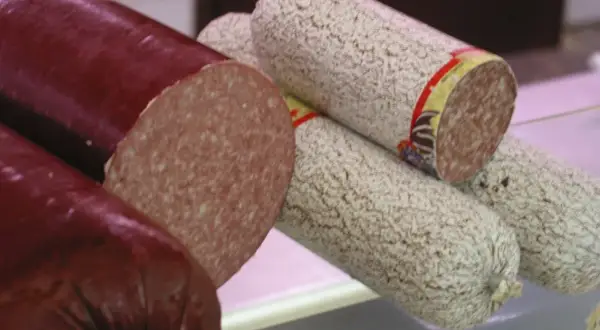 Kawałki ciemnej i jasnej salami, z czego jest salami, widać przekrój.