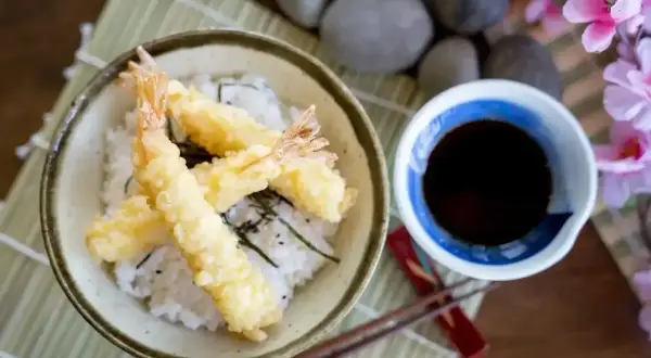 Chrupiące krewetki w cieście, czyli tempura, podane z ryżem i sosem.