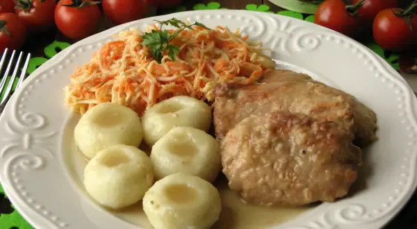 Bitki wieprzowe w sosie własnym z cebulką, podane z kluskami śląskimi i surówką z marchewki. Pyszny, domowy obiad.