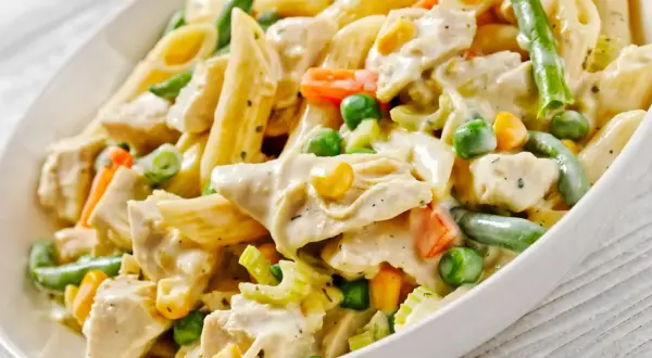 Penne z kurczakiem i kremowym sosem, wzbogacone o zieloną fasolkę, groszek i marchewkę. Pyszny makaron z warzywami.