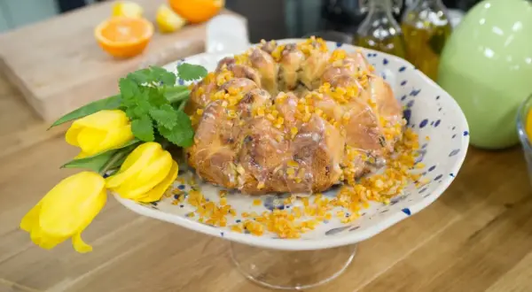 Najłatwiejsza babka drożdżowa z pomarańczą i lukrem, ozdobiona żółtymi tulipanami.