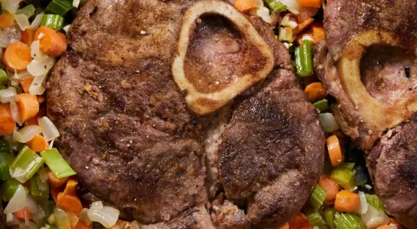Dwa kawałki goleń wołowa z kością, duszone z marchewką i selerem.