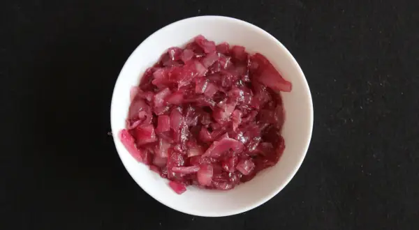 Chutney z czerwonej cebuli w białej miseczce, gotowy do podania.
