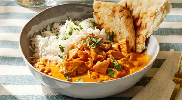 Pyszne butter masala z kurczakiem, ryżem i chlebkiem naan.