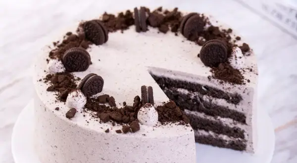 Pyszny tort z masą oreo, udekorowany pokruszonymi ciastkami i całymi ciasteczkami. Idealny na każdą okazję.