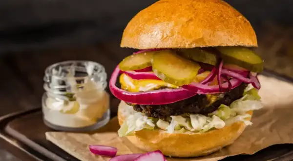 Pyszny hamburger z soczystą wołowiną, chrupiącą sałatą, piklami, czerwoną cebulą i majonezem. Idealny przepis na to, jak zrobić hamburgera.