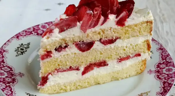 Pyszny biszkopt z serkiem mascarpone i bitą śmietaną, przełożony truskawkami. Idealny deser na każdą okazję.