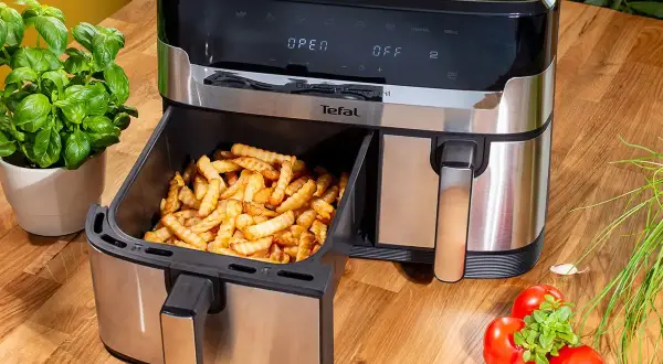 Frytki z frytkownicy beztłuszczowej Tefal, idealne do rankingu air fryer. Obok bazylia i pomidory.