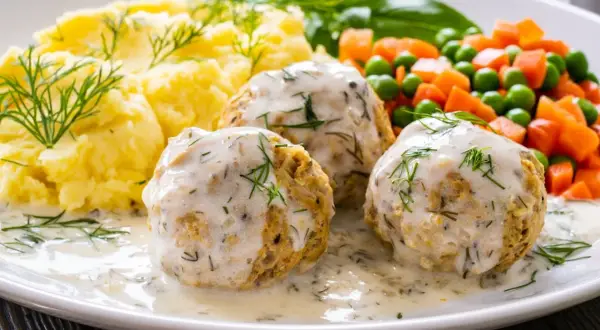 Pyszne pulpety z indyka w sosie koperkowym, podane z puree ziemniaczanym i warzywami.