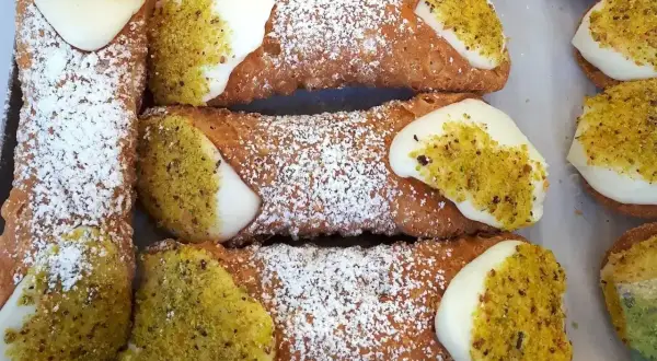 Pyszne, chrupiące rurki z kremem i pistacjami. Idealny dobry przepis na ciasto na rurki, posypane cukrem pudrem.